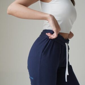 a woman in a white top and blue pants