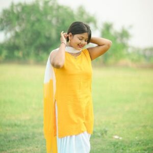 A woman in a yellow top and white pants