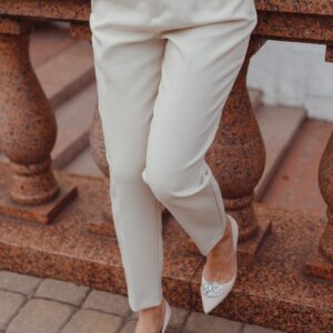 a woman wearing a white suit and heels